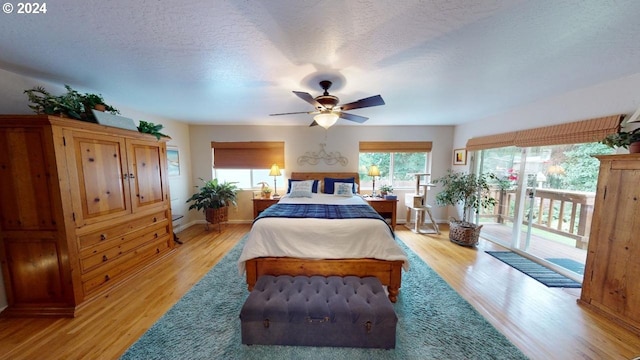 bedroom with a ceiling fan, baseboards, light wood-style floors, a textured ceiling, and access to outside