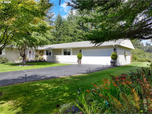 single story home with a front lawn, an attached garage, and driveway