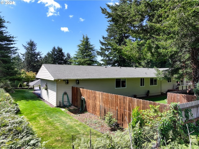 rear view of house with a yard and fence