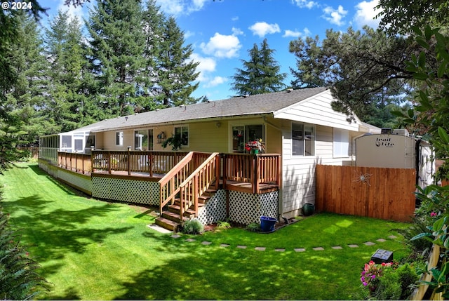 back of property with a lawn and a wooden deck