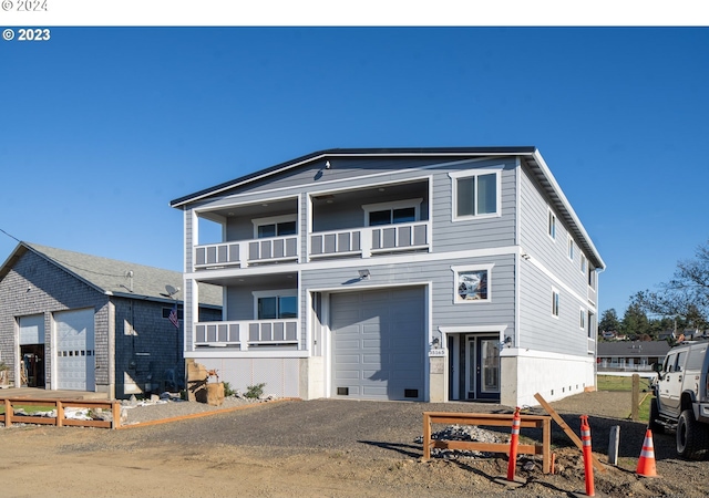 35165 Rueppell Ave, Pacific City, OR 97135 - view of front of house with a balcony, a garage, and gravel driveway