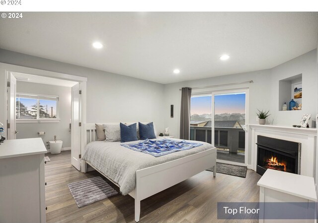 35165 Rueppell Ave, Pacific City, OR 97135 - bedroom with access to outside, multiple windows, recessed lighting, wood finished floors, and a lit fireplace
