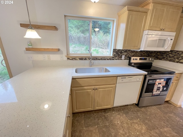 kitchen featuring white appliances, light brown cabinets, a sink, and decorative backsplash