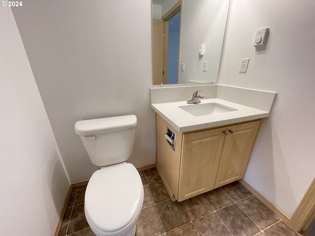 bathroom featuring toilet, tile patterned flooring, baseboards, and vanity