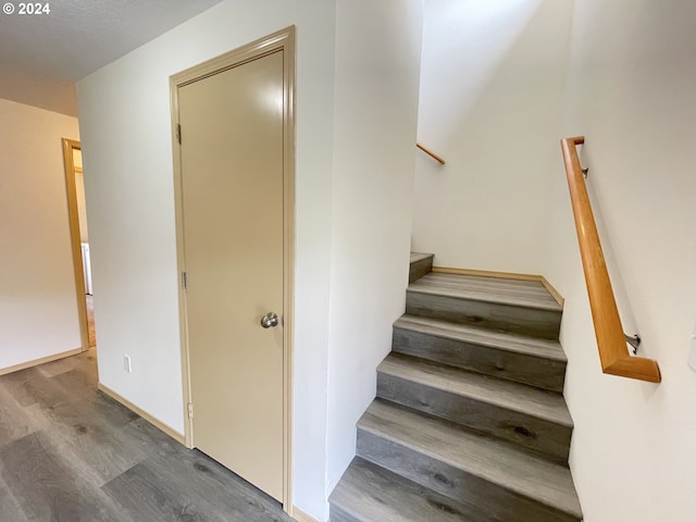 stairway with baseboards and wood finished floors