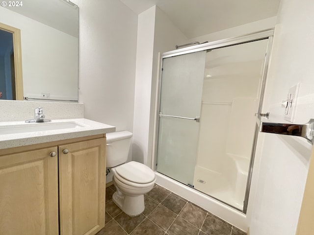 bathroom with walk in shower, vanity, tile patterned flooring, and toilet