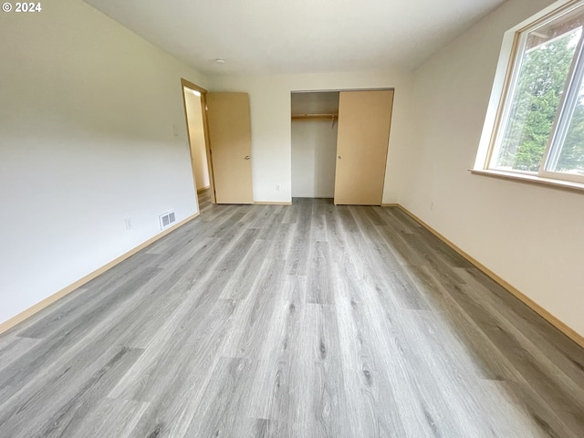 unfurnished bedroom with light hardwood / wood-style floors and a closet