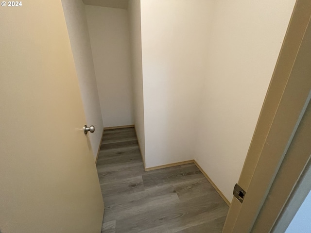 hallway featuring baseboards and wood finished floors