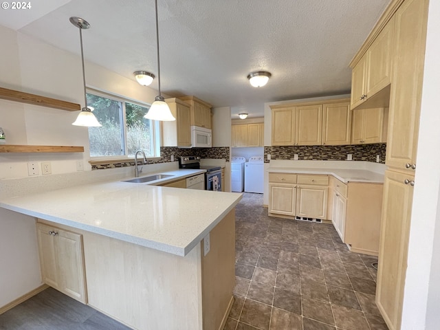 kitchen with light brown cabinetry, white microwave, washing machine and dryer, a sink, and stainless steel electric range