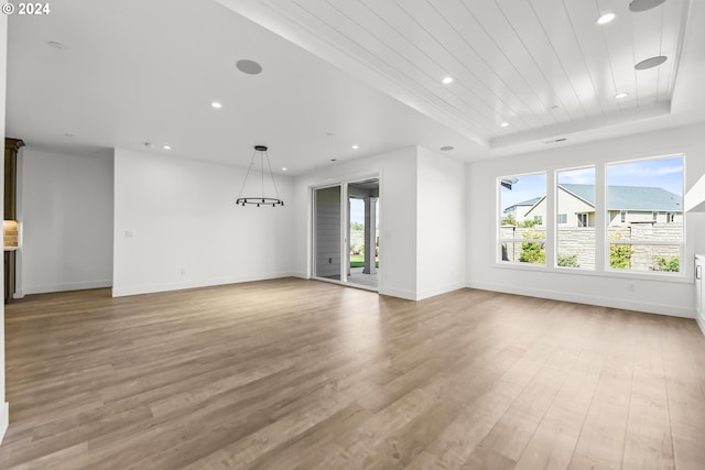 interior space with a tray ceiling and wood-type flooring