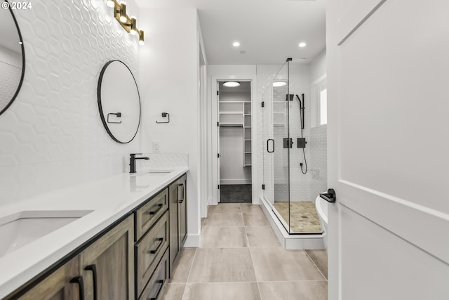 bathroom featuring large vanity, double sink, tile floors, and a shower with door