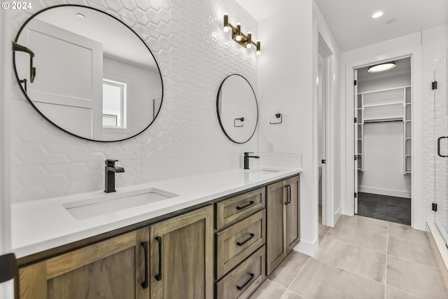 bathroom featuring tile flooring, double sink vanity, and tasteful backsplash