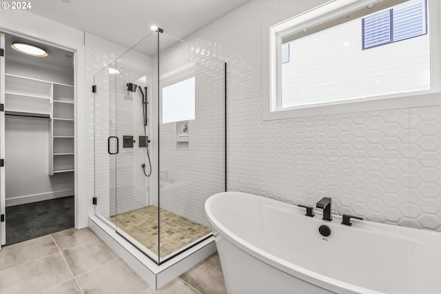 bathroom with tile flooring and shower with separate bathtub