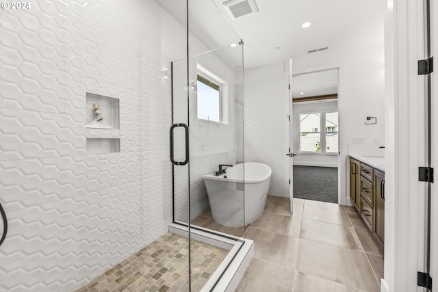 bathroom with tile flooring, shower with separate bathtub, and vanity