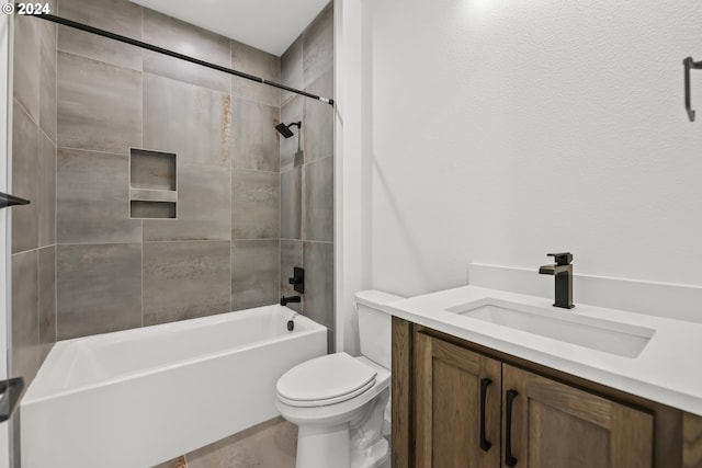 full bathroom featuring tiled shower / bath, vanity, and toilet