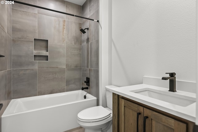 full bathroom with tiled shower / bath combo, vanity, and toilet