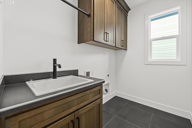 clothes washing area featuring cabinets, electric dryer hookup, dark tile flooring, washer hookup, and sink