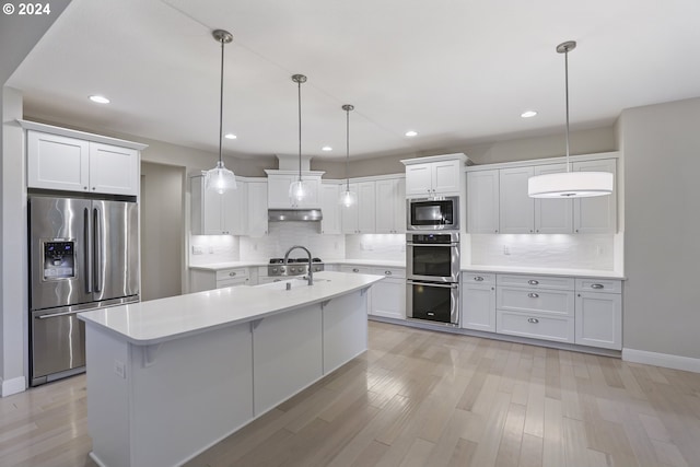 kitchen featuring white cabinets, hanging light fixtures, stainless steel appliances, and tasteful backsplash