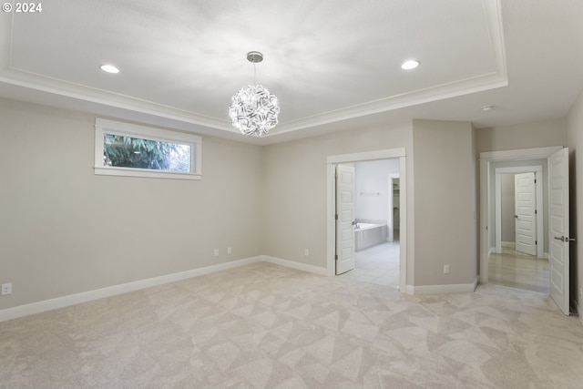 tiled spare room featuring a chandelier and a raised ceiling