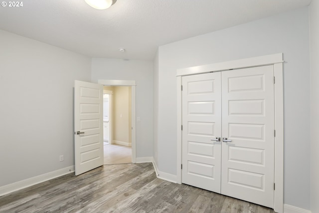 unfurnished bedroom featuring hardwood / wood-style floors and a closet