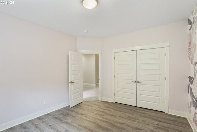 unfurnished bedroom featuring a closet and wood-type flooring