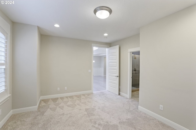 spare room featuring light colored carpet