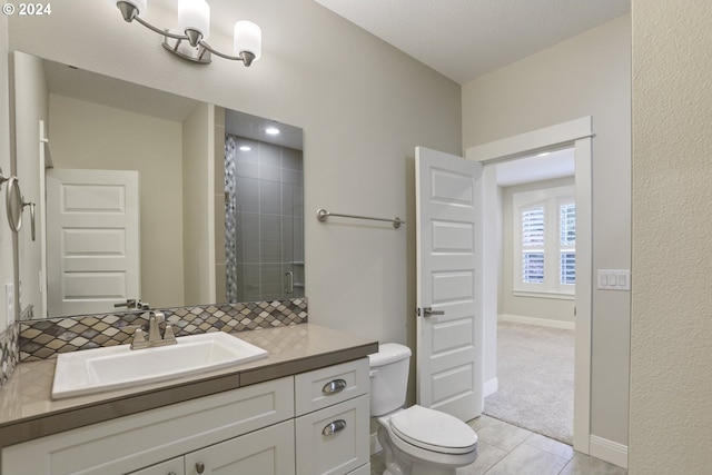 bathroom with a shower with door, vanity, tasteful backsplash, tile patterned flooring, and toilet