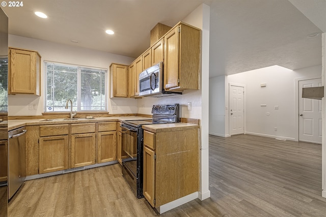 kitchen with sink, stainless steel appliances, and light wood-type flooring