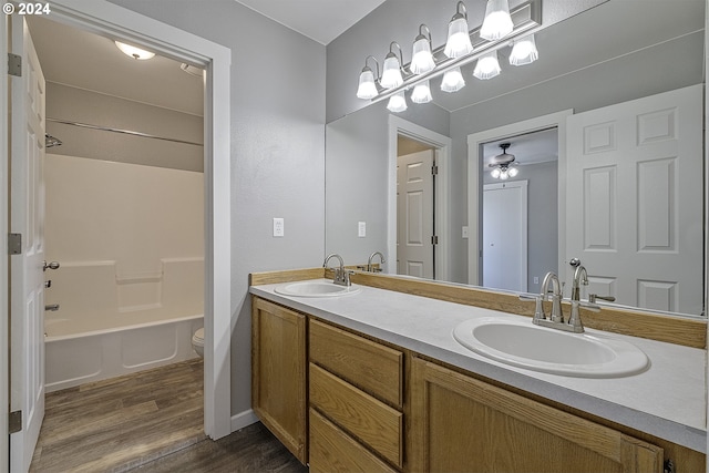 full bathroom featuring vanity, ceiling fan, washtub / shower combination, hardwood / wood-style floors, and toilet