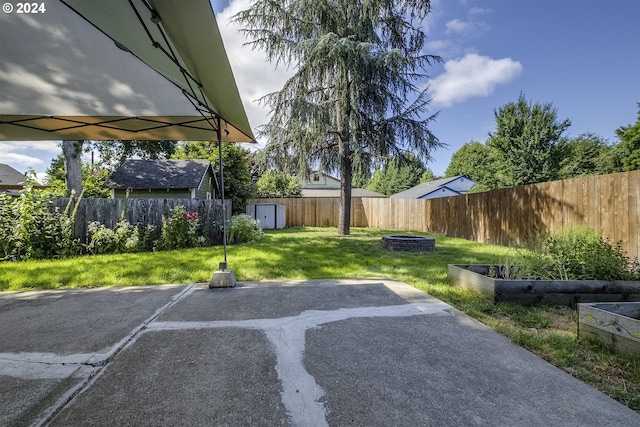 view of yard with a fire pit and a storage unit