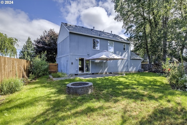 rear view of house featuring a yard, an outdoor fire pit, and a patio area