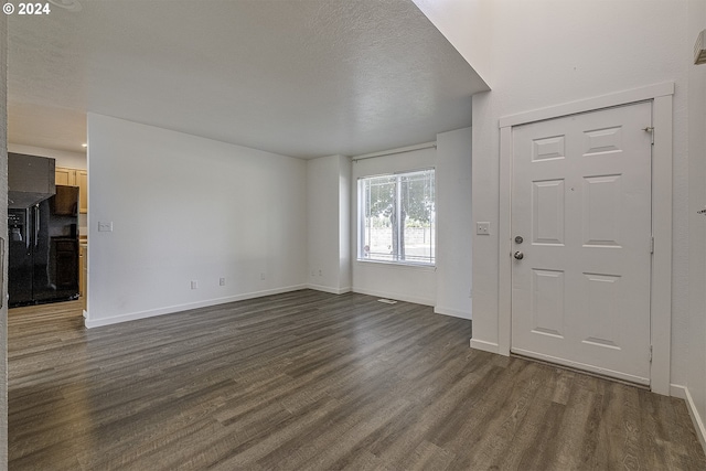 entrance foyer featuring a textured ceiling and dark wood-type flooring