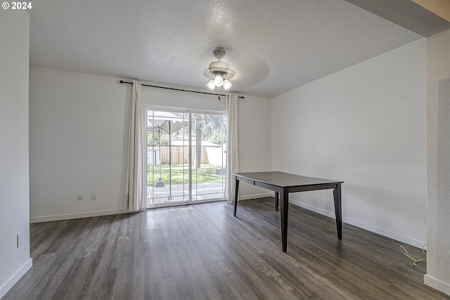 unfurnished dining area featuring ceiling fan and dark wood-type flooring