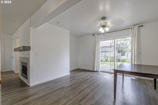 unfurnished living room with a textured ceiling, dark hardwood / wood-style floors, and ceiling fan