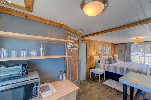 bedroom featuring hardwood / wood-style flooring, beam ceiling, and wooden walls