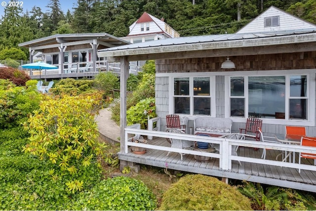 rear view of house featuring a wooden deck