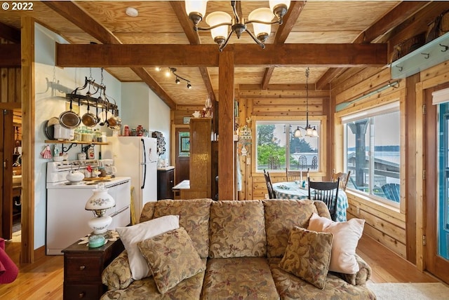 12880 Hobsonville Point Dr, Bay City, OR 97107 - living area featuring a chandelier, wooden ceiling with exposed beams, wood walls, light wood-style flooring, and plenty of natural light