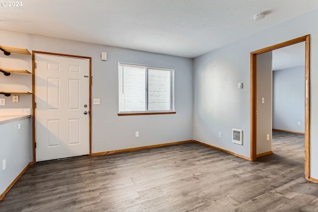 entrance foyer with heating unit and hardwood / wood-style floors