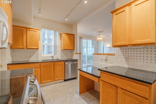 kitchen with dishwasher, a sink, dark stone counters, decorative backsplash, and range