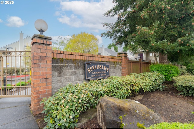 community / neighborhood sign featuring fence