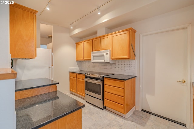 kitchen featuring light brown cabinets, white appliances, dark stone counters, decorative backsplash, and rail lighting