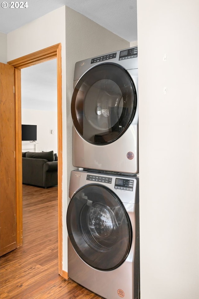 washroom featuring stacked washer and dryer and hardwood / wood-style floors