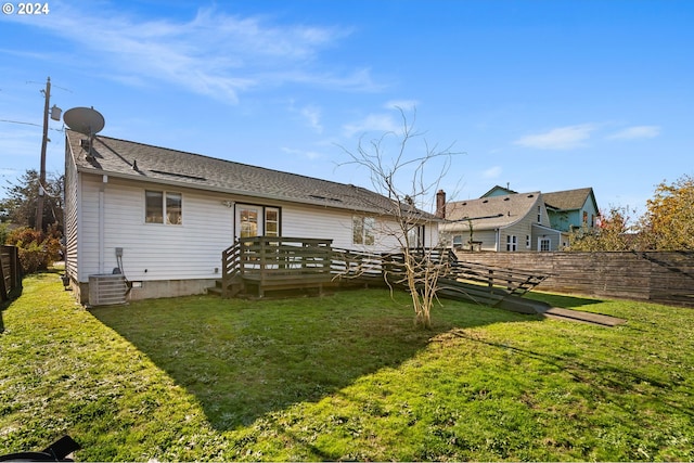 rear view of property featuring a lawn and a deck