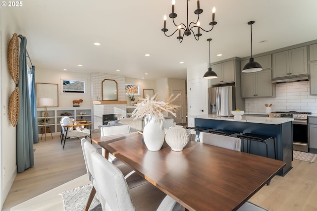 dining area with light hardwood / wood-style flooring and an inviting chandelier