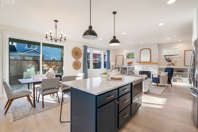 kitchen with open floor plan, light countertops, a kitchen island, and decorative light fixtures