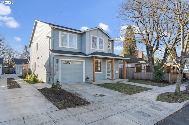 traditional home with a garage, driveway, board and batten siding, and fence