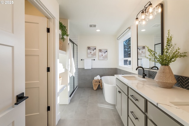 bathroom with a sink, visible vents, a soaking tub, a shower stall, and tile patterned floors