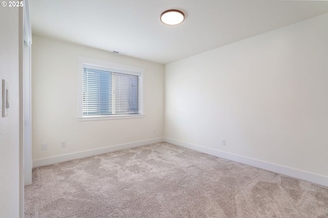 spare room with light carpet, visible vents, and baseboards