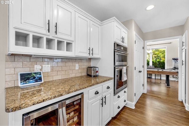 kitchen with white cabinets, dark stone countertops, and wine cooler