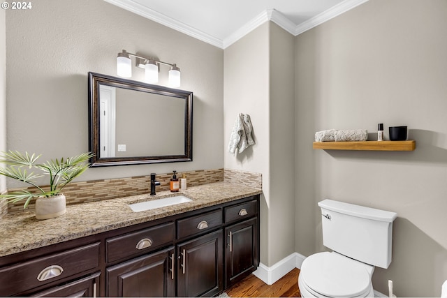 bathroom with hardwood / wood-style floors, vanity, backsplash, toilet, and ornamental molding